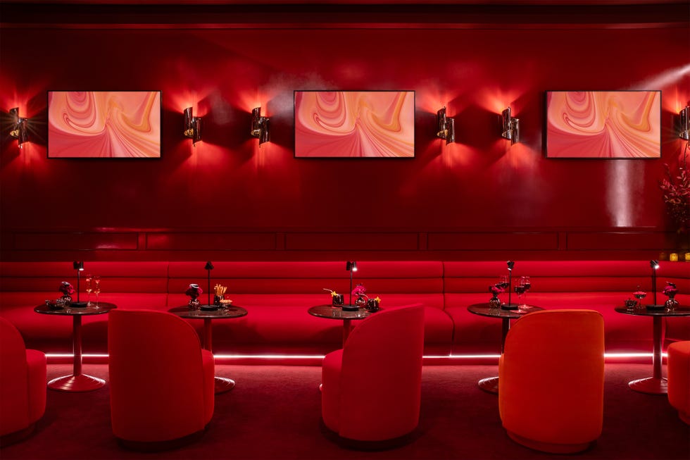 Elegant lounge featuring red decor, modern artwork, and intimate seating arrangements.