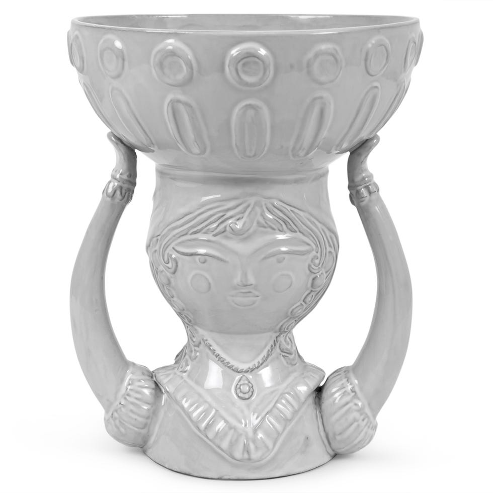 Ceramic vase designed in the shape of a woman with raised arms supporting a bowl.