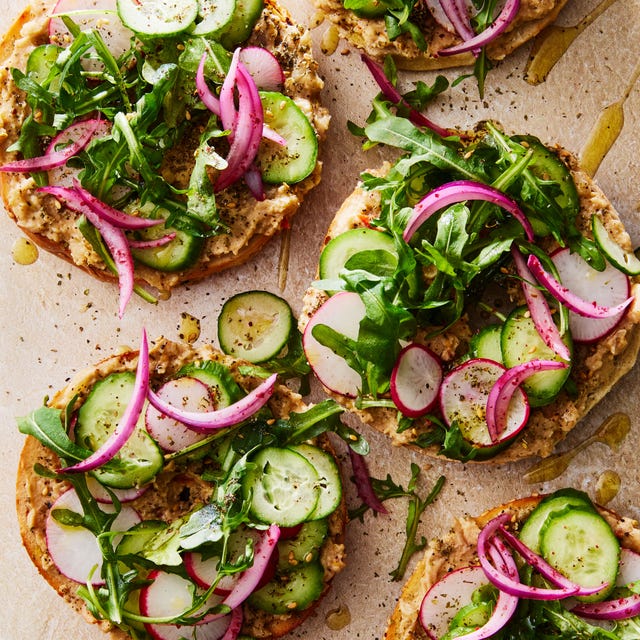 Baba Ghanoush Bagel Sandwich bagel topped with baba ghanoush, sliced cucumber, arugula, and red onions