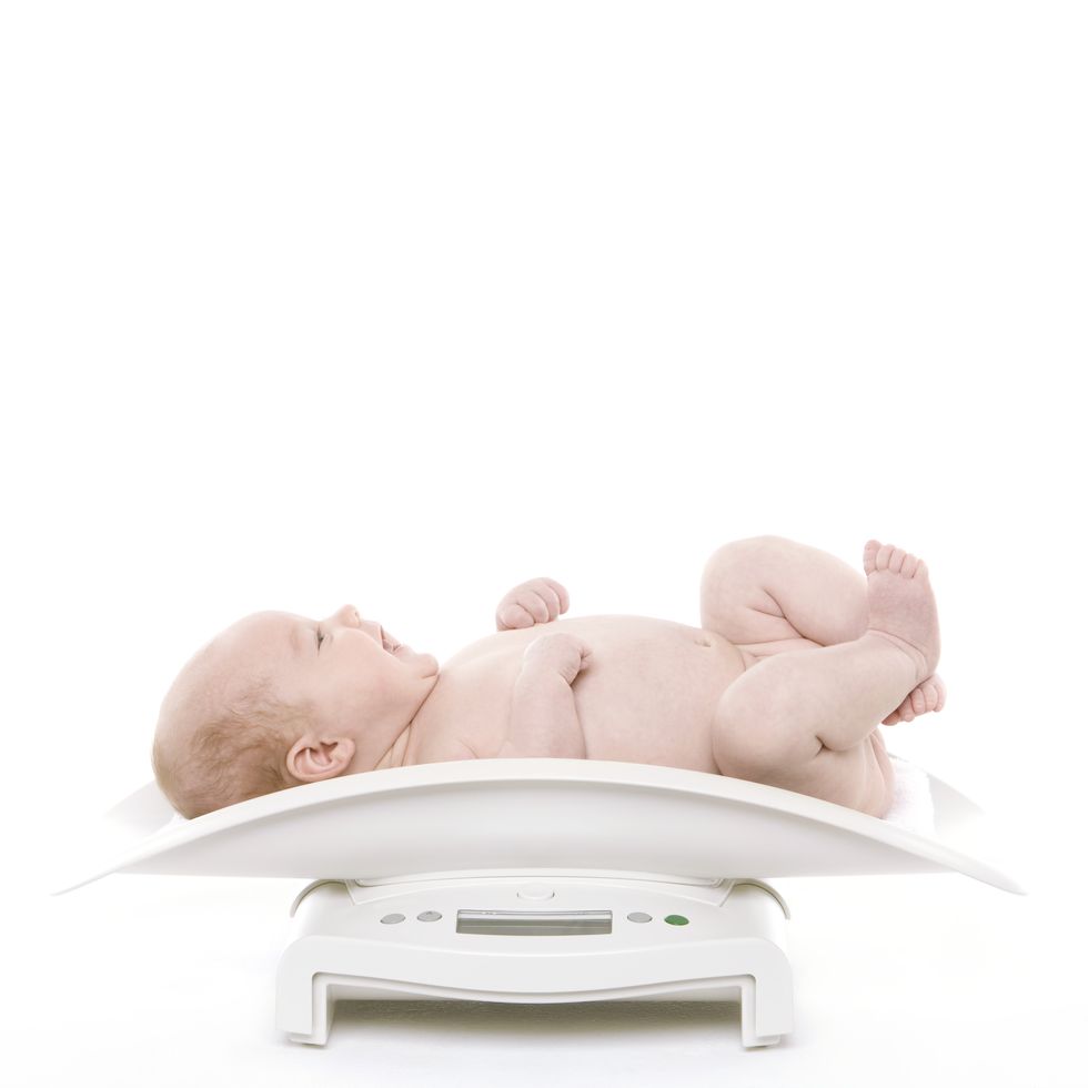 el bebé se pesa en una báscula para recién nacidos