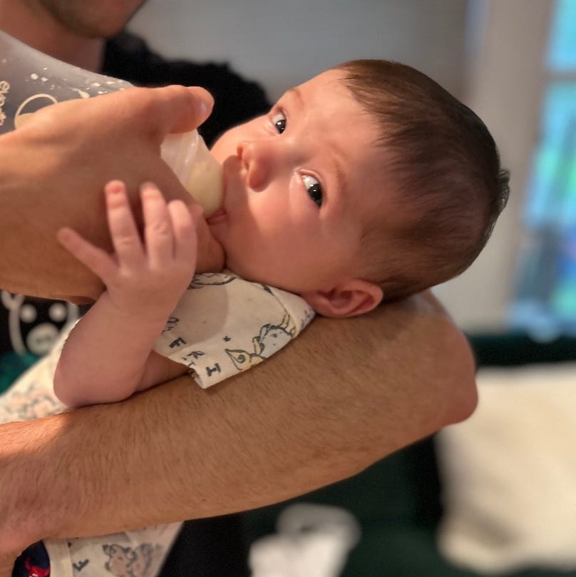 a baby drinks from a bottle so the parents can provide feedback to good housekeeping