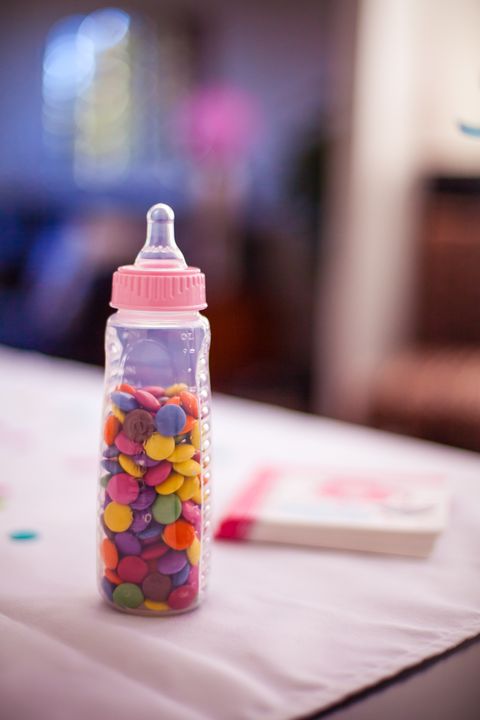 Baby bottle filled with candies at a baby shower
