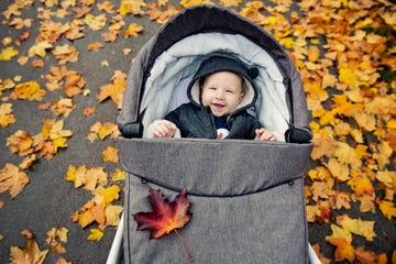 bebe sonriendo en carrito abrigado