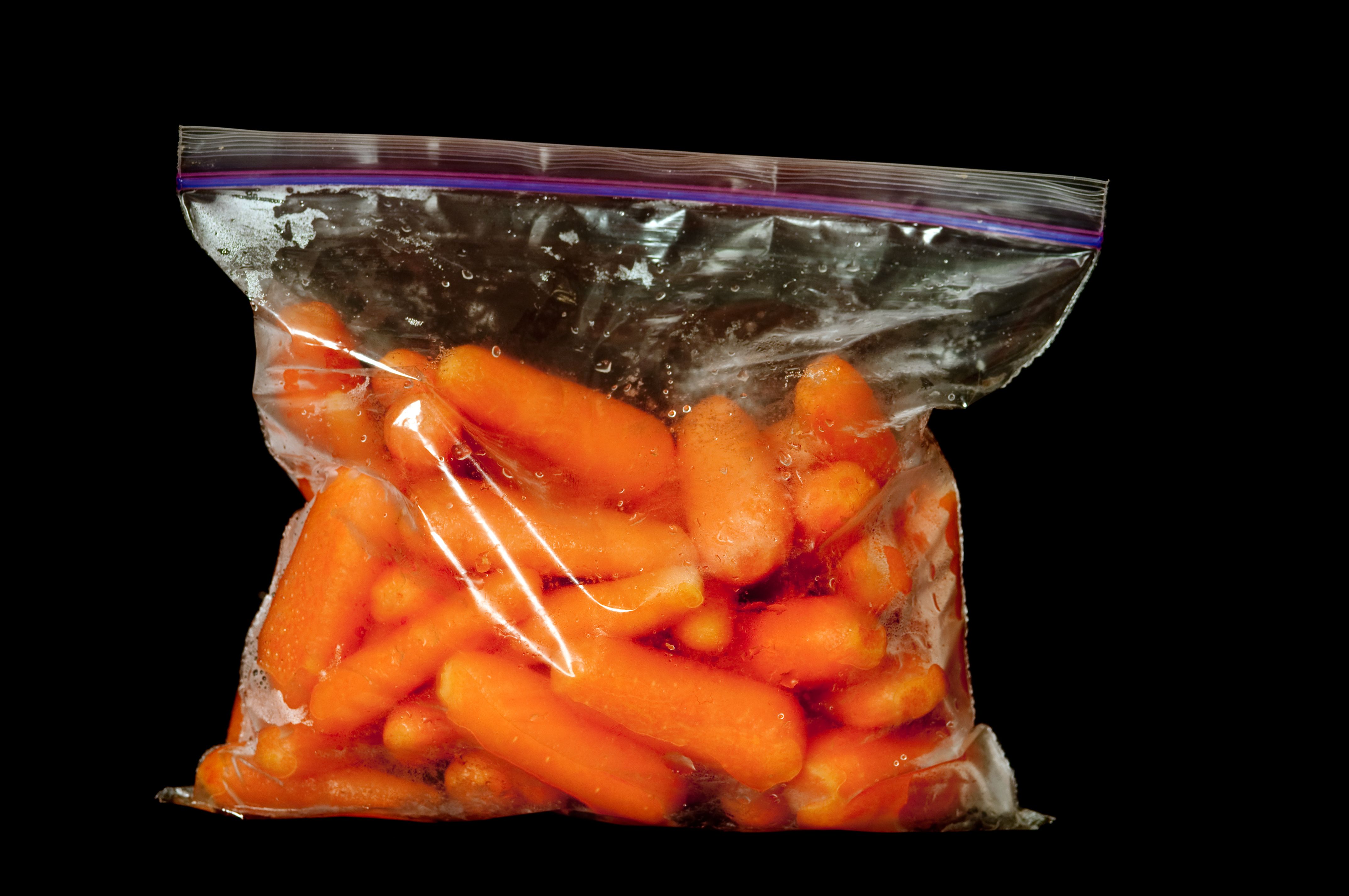 Fresh baby carrots in plastic bags in the grocery store Stock Photo - Alamy