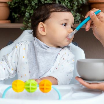 parent feeding baby cereal with spoon