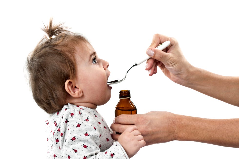 bebé tomando un analgésico en jarabe de una cuchara