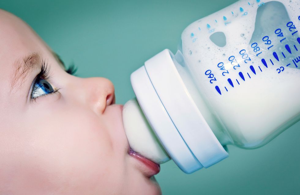 baby drinking milk or formula from a baby bottle