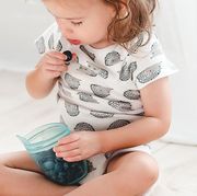 toddler with blueberries in a zip top food storage container
