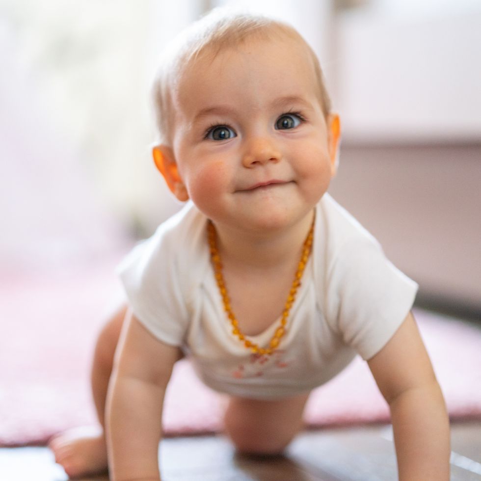 baby girl crawling on the floor at home