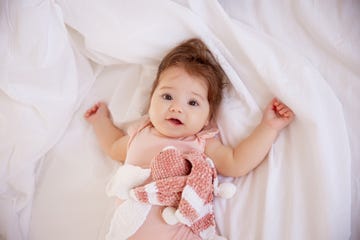 nina bebe tumbada con peluche