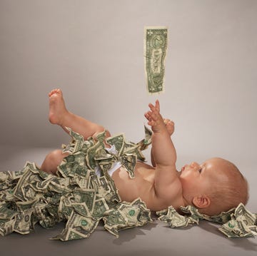 Baby girl (5 months) lying down covered with us dollar bills falling from above baby girl 5 months lying down covered with us dollar bills falling from above