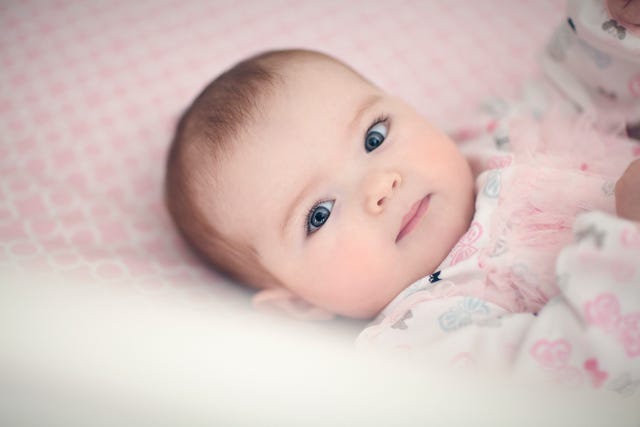 bebe nina con ojos azules en la cuna