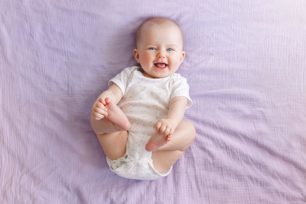 bebé riendo en una cama
