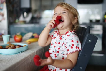 nina con fresas en dedos de las manos