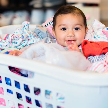 baby sitting in laundry basket
