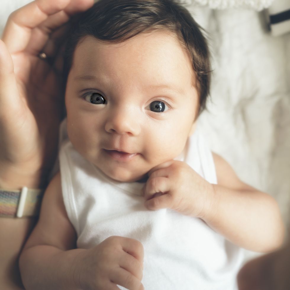 baby making eye contact with his mother