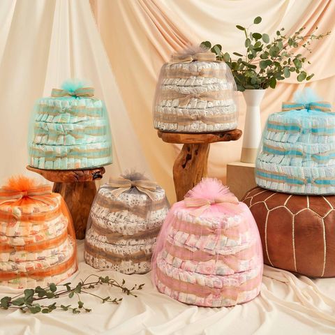 a set of diaper cakes on a draped backdrop