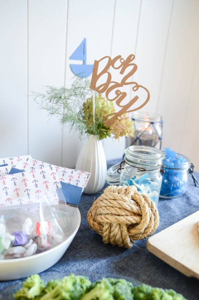 a nautical themed party table with a rope knot, oh boy sign and blue accents