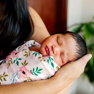 mom holding baby in floral print swaddle