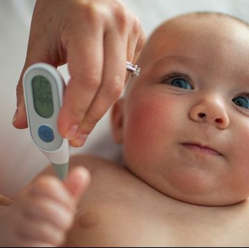 thermometer taking baby's temperature in armpit