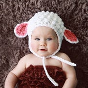 March birthday facts baby wearing lamb hat