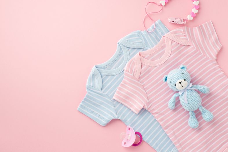 a pink babygrow next to a blue babygrow to represent a boy and girl baby