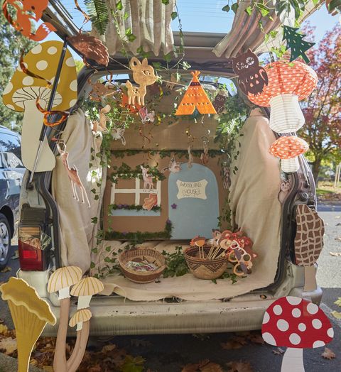 back of a retro van decorated as a woodland house with mushrooms for a halloween trunk or treat