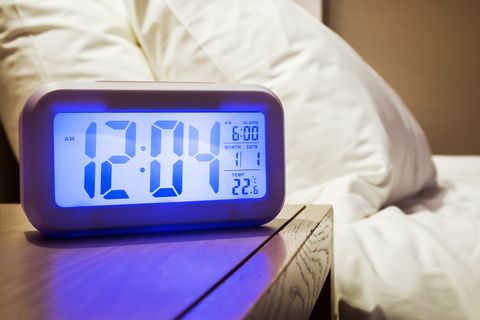 electronic alarm clock stands on a bedside table in the room