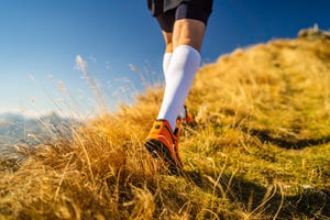 back view detail legs of cross country runner in mountains