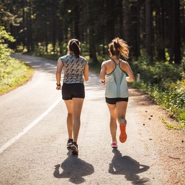 twee vrouwen hardlopend op weg door bos