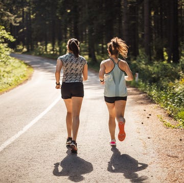 Back view of female athletes running on road in forest what causes a side stitch while running back view of female athletes running on road in forest