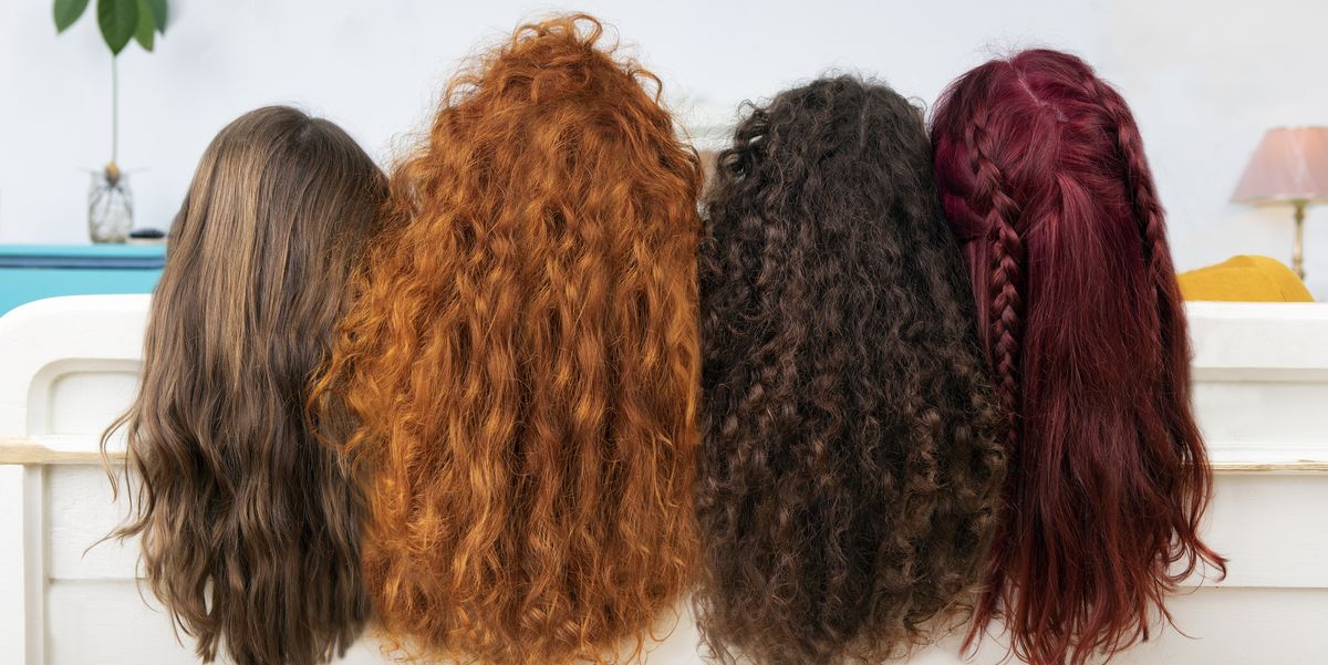 back view of four women with long brown and red hair