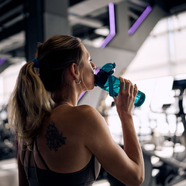 back view of woman hydrating after gym workout