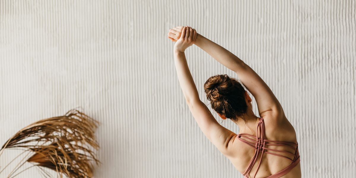 https://hips.hearstapps.com/hmg-prod/images/back-view-of-young-woman-doing-yoga-against-a-gray-royalty-free-image-1750807647.pjpeg?crop=0.897xw:0.673xh;0.103xw,0.212xh&resize=1200:*