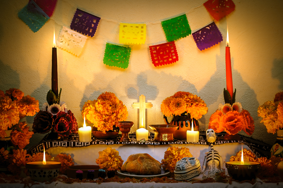 day of the dead altar with marigold flowers, candles, and food