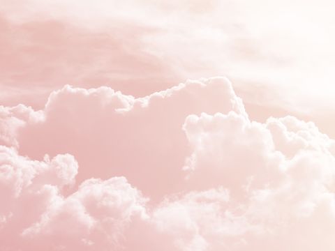 Background of a sky of pink soft color with white clouds.