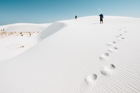 backpackers hiking on the desert dunes