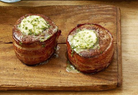bacon wrapped filets with cowboy butter on wood surface