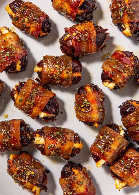 close up of bacon wrapped dates garnished with herbs
