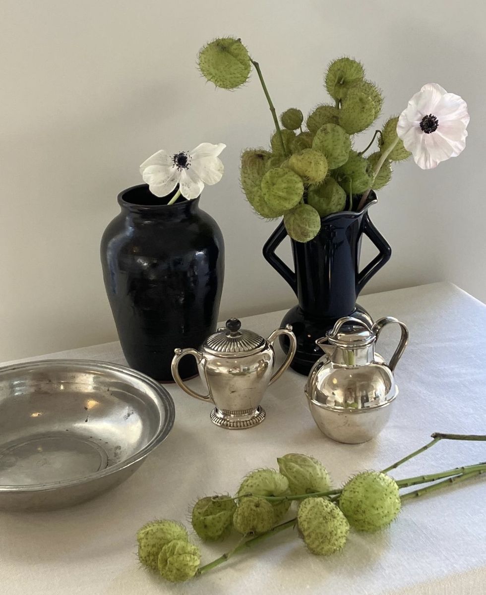 a table with flowers and teapots