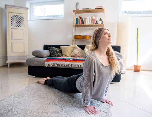 Una bailarina hace estiramientos en casa durante la cuarentena por el nuevo coronavirus COVID-19.