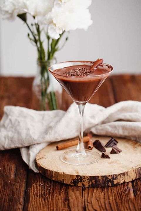 chocolate martini on wood log with white flowers in back