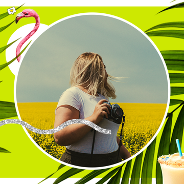 woman walking in a field holding a camera