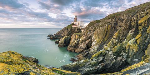 Baily lighthouse, Howth, County Dublin, Ireland, Europe. Panoramic view of the cliff and the lighthouse at sunrise.