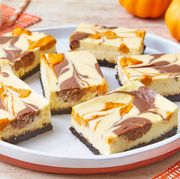 bake sale ideas cheesecake bars with pumpkin and glass of milk in back