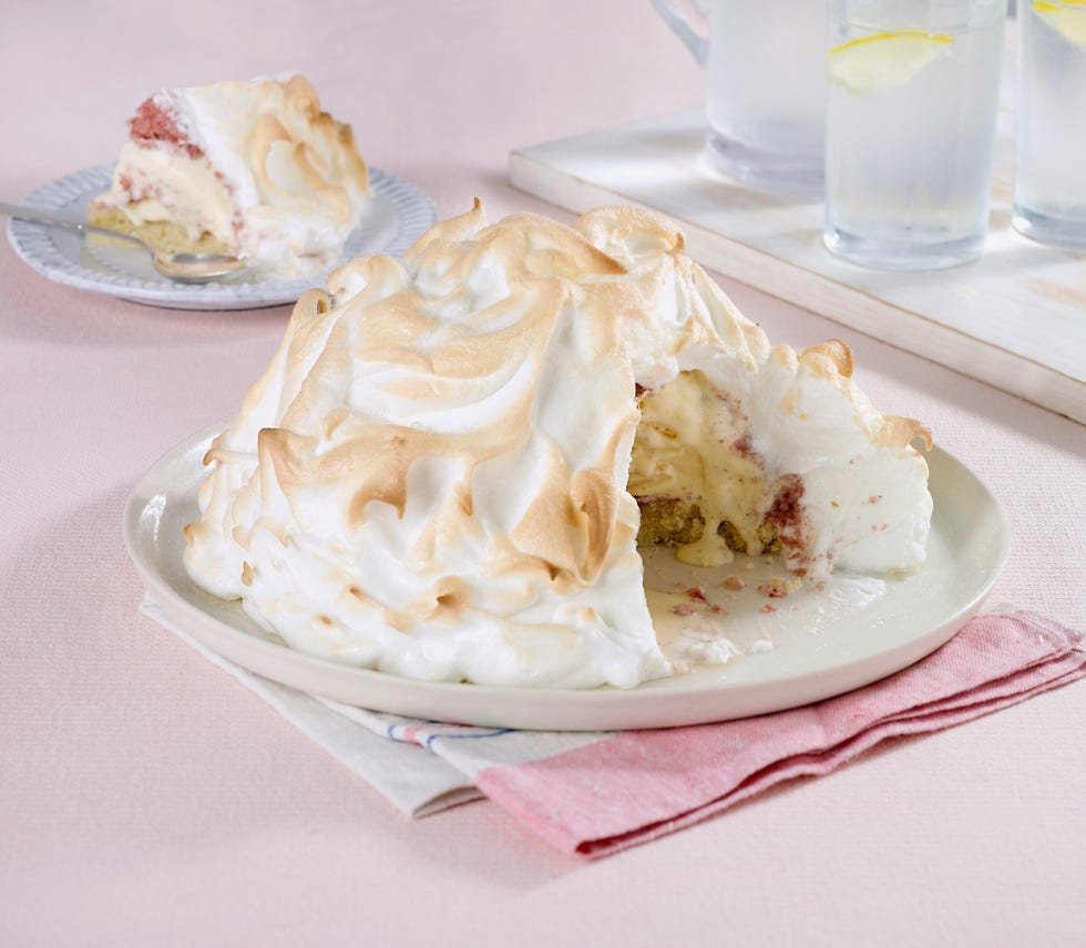 Baked Alaska with slice removed showing ice cream and sponge cake with strawberry