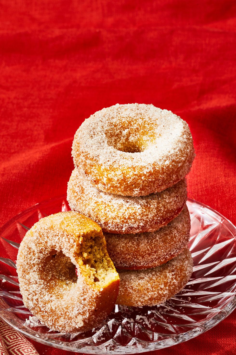 baked applesauce donuts stacked on a glass plate