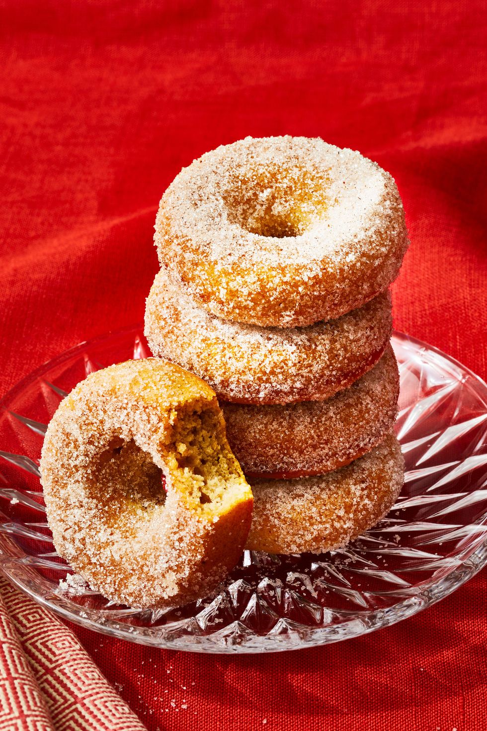 baked applesauce donuts stacked on a glass plate