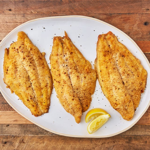 baked catfish topped with salt and pepper and served with lemon wedges