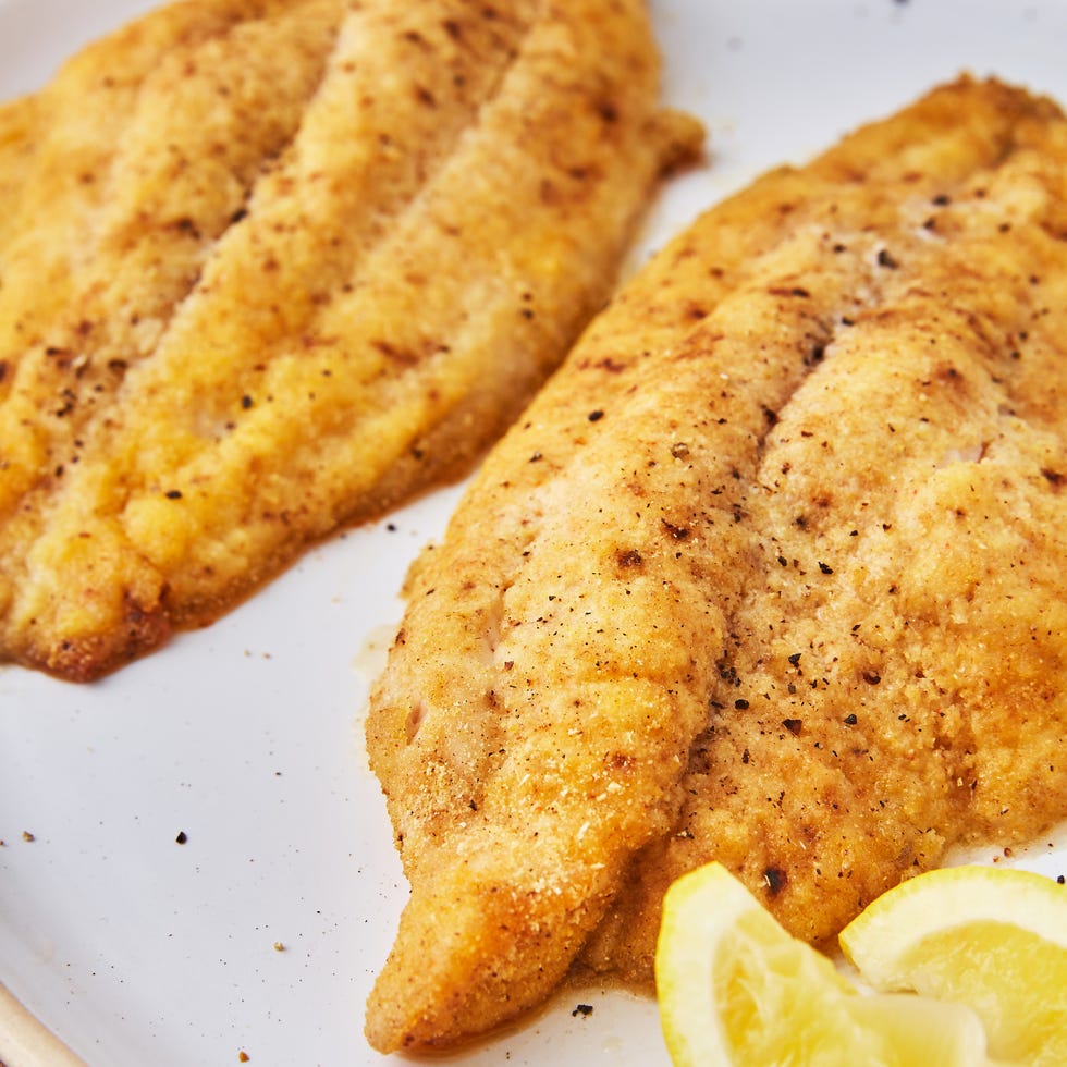 baked catfish topped with salt and pepper and served with lemon wedges